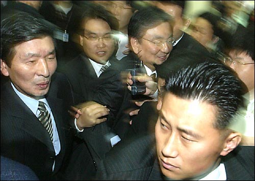 지난 2005년 11월 12일 귀국한 홍석현 전 주미대사(<중앙일보> 사주)가 김포공항을 빠져나가는 과정에서 권영빈 <중앙일보> 사장 겸 발행인·편집인(왼쪽)과 기자들이 인터뷰를 시도하는 다른 언론사 기자들과 몸싸움을 벌이고 있다.